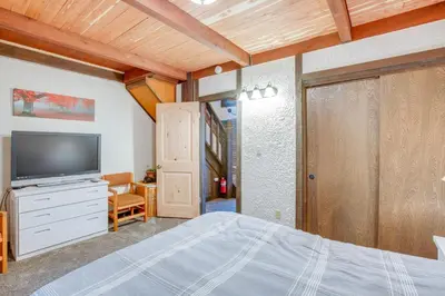 a bedroom with a bed and a flat screen tv at 1 Mi to Stagecoach Lift! Homey Tahoe Townhome in Stateline
