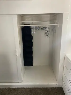 a walk in closet with white cabinets and a black towel at Midtown Charm: 1BR Urban Pad in Reno