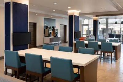 a waiting room with a table and chairs at Holiday Inn Express & Suites Fresno Airport by IHG in Fresno