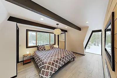 a bedroom with a bed and a large window at Modern Gambrel Cabin Near Ski Resorts in Truckee