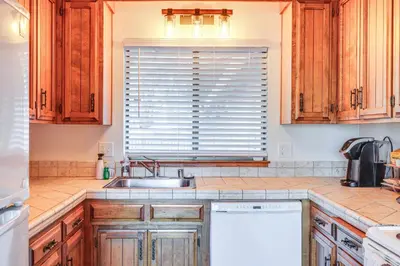 a kitchen with wooden cabinets and a sink and a window at Groveland Home with Deck 2 Mi to Pine Mountain Lake in Groveland