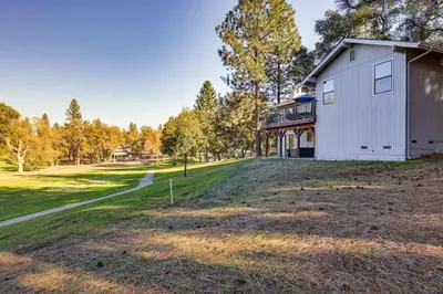 a white house on a hill next to a field at Groveland Home with Deck 2 Mi to Pine Mountain Lake in Groveland