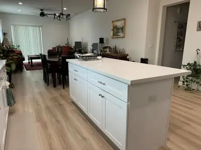 a kitchen with a white island in a living room at Brand New South Sacramento Home in Sacramento