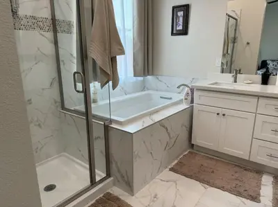 a bathroom with a shower and a tub and a sink at Brand New South Sacramento Home in Sacramento