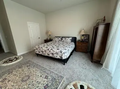 a bedroom with a bed and a dresser and a door at Brand New South Sacramento Home in Sacramento