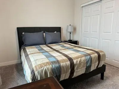 a bedroom with a bed and a white door at Brand New South Sacramento Home in Sacramento