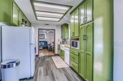 a kitchen with green cabinets and a white refrigerator at Mountain Home Near Yosemite with Well-Being Retreat! in Ahwahnee
