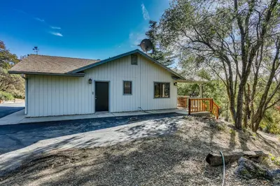 a white house with a porch and a driveway at Mountain Home Near Yosemite with Well-Being Retreat! in Ahwahnee