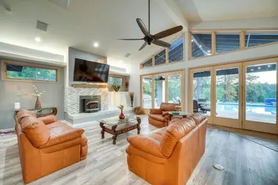 a living room with leather furniture and a ceiling fan at Mansion, Pool, Game Room in Pollock Pines