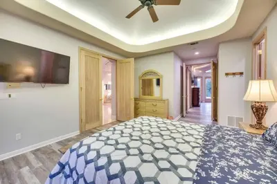 a bedroom with a large bed and a flat screen tv at Mansion, Pool, Game Room in Pollock Pines