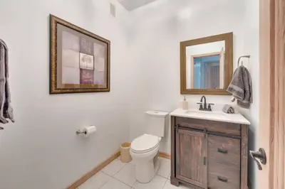 a bathroom with a toilet and a sink and a mirror at Mansion, Pool, Game Room in Pollock Pines