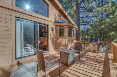 a cabin with a grill and chairs on a deck at Home 1 Mi to Downhill Ski Resort Bring Your Pets! in Truckee