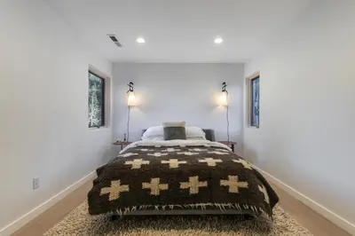 a bedroom with a bed with a brown blanket at Open Air at Palisades - 3 BR, Brand New Construction - Wrap-Around Deck w Hot Tub in Olympic Valley
