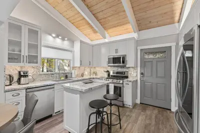 a kitchen with white cabinets and a table and chairs at Tahoe Bliss: Ski, Hike, & Relax in Incline Village