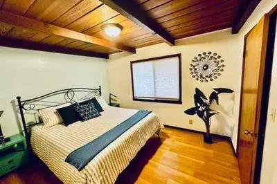 a bedroom with a large bed and a window at Blue Door Cottage 12 miles to Yosemite Bbq in Oakhurst