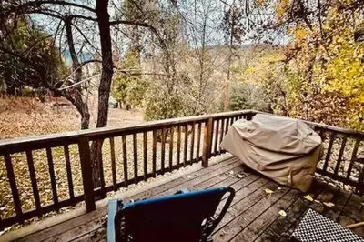a bench with a tent and a chair on a balcony at Blue Door Cottage 12 miles to Yosemite Bbq in Oakhurst