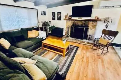 a living room with a green couch and a fireplace at Red Door Cottage Fireplace bbq 12 mi to Yosemite in Oakhurst