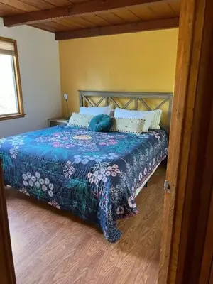 a bedroom with a bed with a blue comforter at Orange Door Electric Fireplace bbq in Oakhurst