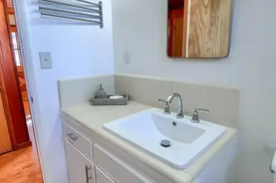 a bathroom with a white sink and a mirror at Orange Door Electric Fireplace bbq in Oakhurst