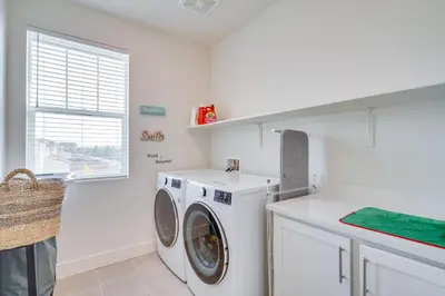 a laundry room with a washing machine and a window at Newly Built Tracy Home with Backyard and Pool Access! in Tracy