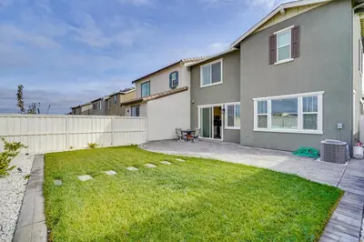 a house with a fence and a yard at Newly Built Tracy Home with Backyard and Pool Access! in Tracy