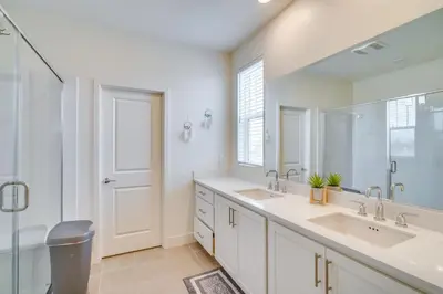 a bathroom with two sinks and a large mirror at Newly Built Tracy Home with Backyard and Pool Access! in Tracy
