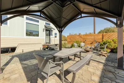 a patio with a wooden picnic table and chairs at Tiny Home | Lewis Ranch 1 in Lindsay
