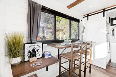 a room with a table and chairs and a window at Tiny Cargo Home South in Tulare