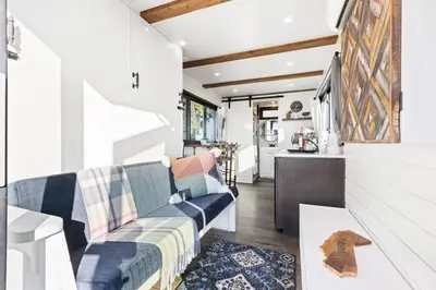 a living room with a couch and a kitchen at Tiny Cargo Home South in Tulare