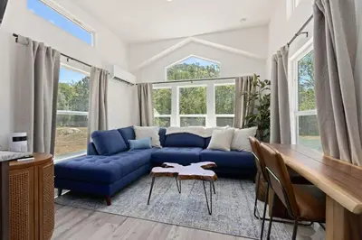 a living room with a blue couch and a table at Tiny River House in Three Rivers