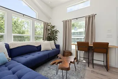 a living room with a blue couch and a table at Tiny River House in Three Rivers