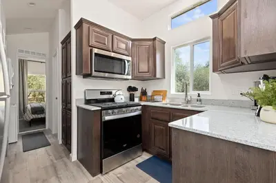 a kitchen with wooden cabinets and a stove top oven at Tiny River House in Three Rivers