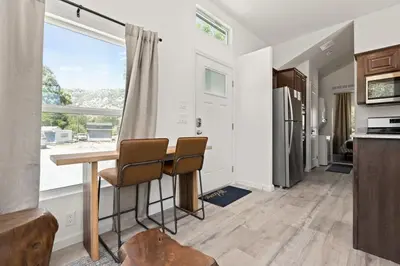 a kitchen with a table and chairs and a window at Tiny River House in Three Rivers
