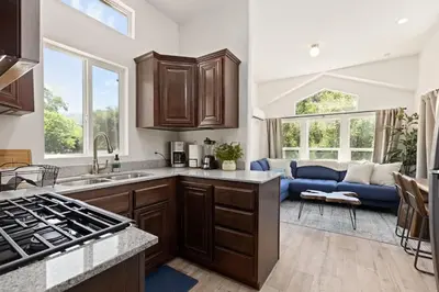 a kitchen with wooden cabinets and a blue couch at Tiny River House in Three Rivers