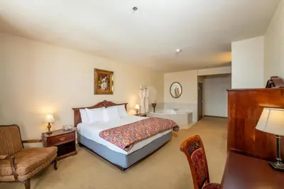 a hotel room with a bed and a bath tub at Silverland Inn in Virginia City