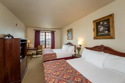 a hotel room with two beds and a television at Silverland Inn in Virginia City