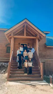 a group of people standing on the stairs of a house at 4 Kings Log Cabin 150 Acres Spectacular Views in Three Rivers