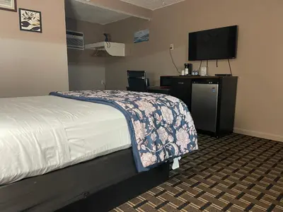 a hotel room with a bed and a flat screen tv at Dream Inn in Tonopah