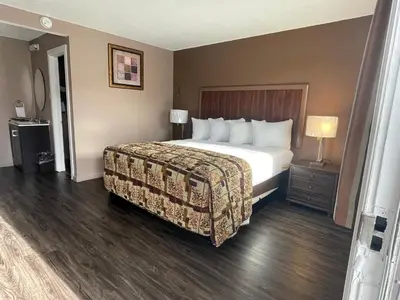 a hotel room with a large bed and a lamp at Dream Inn in Tonopah