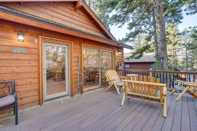 a cabin with a deck with chairs and a table at 4 Mi to Slopes Family-Friendly Stateline Home! in Stateline