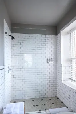 a bathroom with a white tiled shower and a window at The Jesse Hotel & Bar in Reno