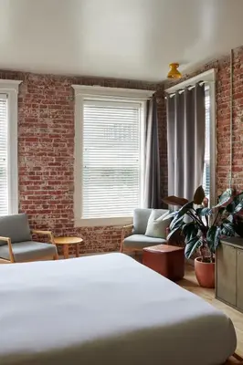 a room with a bed and a brick wall at The Jesse Hotel & Bar in Reno