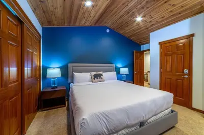a blue bedroom with a bed and a blue wall at Luxury Townhome, Walk to the Village, Wifi, Private Spa & Garage in Mammoth Lakes