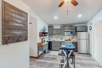 a kitchen with gray cabinets and a refrigerator at 1BR Dog-Friendly Lakefront Cabin with Canoes in Twain Harte