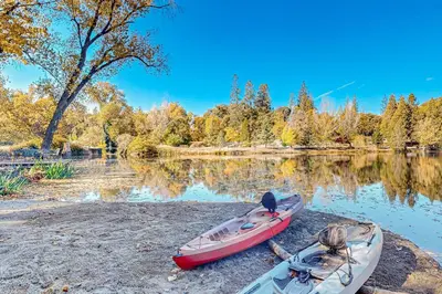two canoes sitting on the shore of a lake at 1BR Dog-Friendly Lakefront Cabin with Canoes in Twain Harte