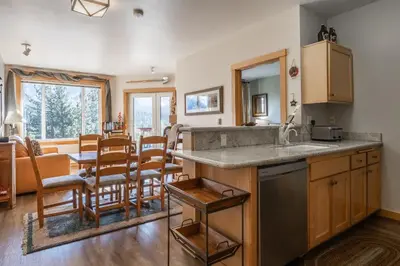a kitchen and dining room with a table and chairs at Juniper Springs Lodge #412 - Luxury Ski in Ski out! 2 Bedroom in Mammoth Lakes