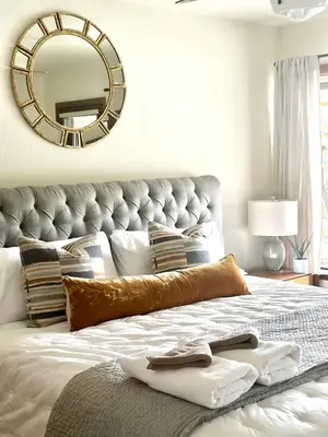 a bedroom with a large bed with a gold mirror at Luxury Yosemite Lake House in Groveland