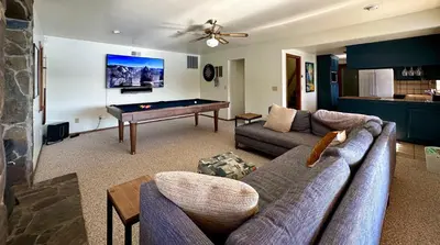 a living room with a couch and a pool table at Luxury Yosemite Lake House in Groveland