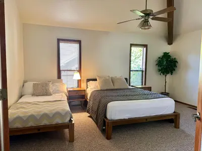 a bedroom with two beds and a ceiling fan at Luxury Yosemite Lake House in Groveland