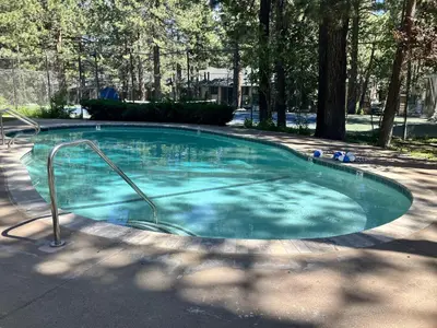 a swimming pool with blue water in a park at Horizons 4 158 in Mammoth Lakes